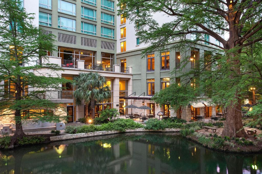 圣安东尼奥Hotel Contessa - Suites on the Riverwalk的一座建筑前有池塘的酒店