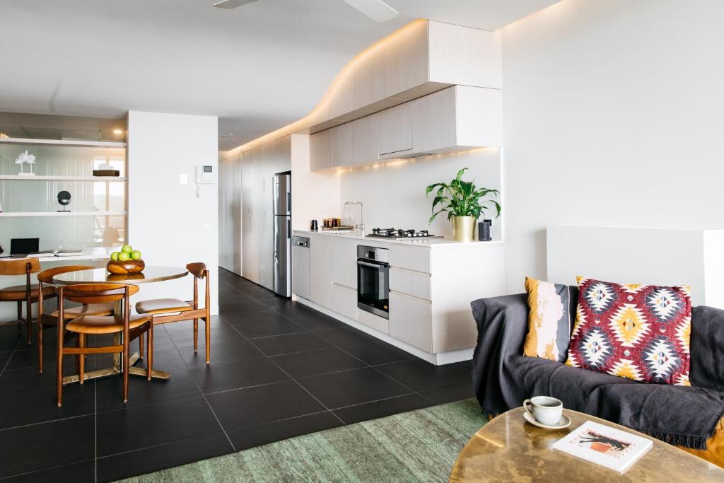 堪培拉欧沃洛尼实生态公寓式酒店的客厅以及带沙发和桌子的厨房。