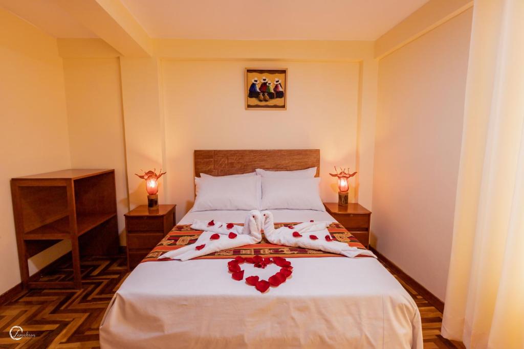 库斯科Quechua Hostal Recoleta的一间卧室,床上有红色玫瑰