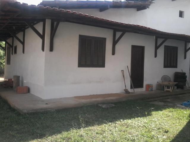 曼加拉蒂巴Pousada Sro Adilson的白色的建筑,有黑色的窗户和草地庭院