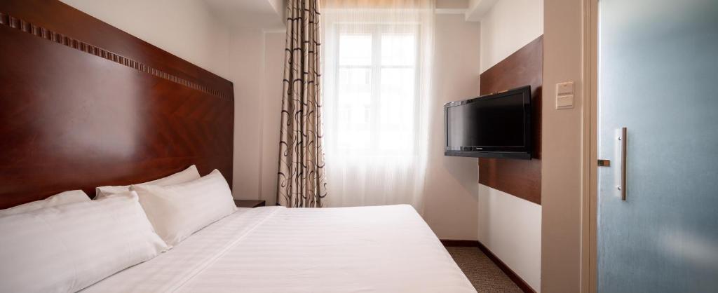 新加坡The Quay Hotel West Coast的一间卧室设有一张带平面电视的床。