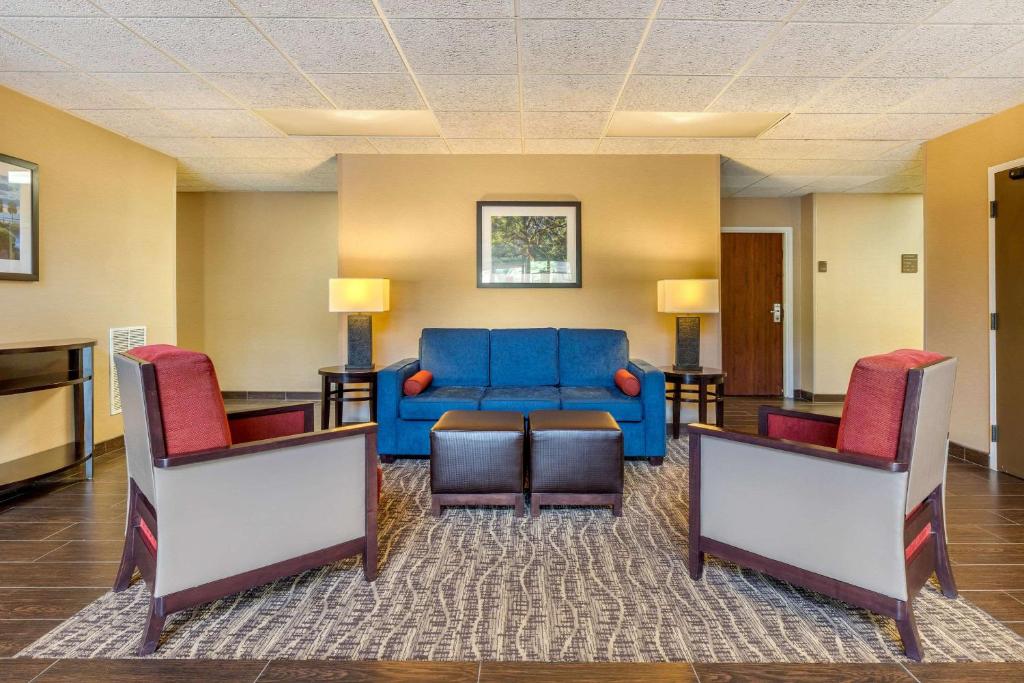 萨默维尔Comfort Inn Summerville - Charleston的客厅配有蓝色的沙发和两把椅子