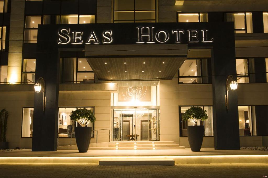 安曼Seas Hotel Amman的一座大型建筑,晚上有海洋酒店标志