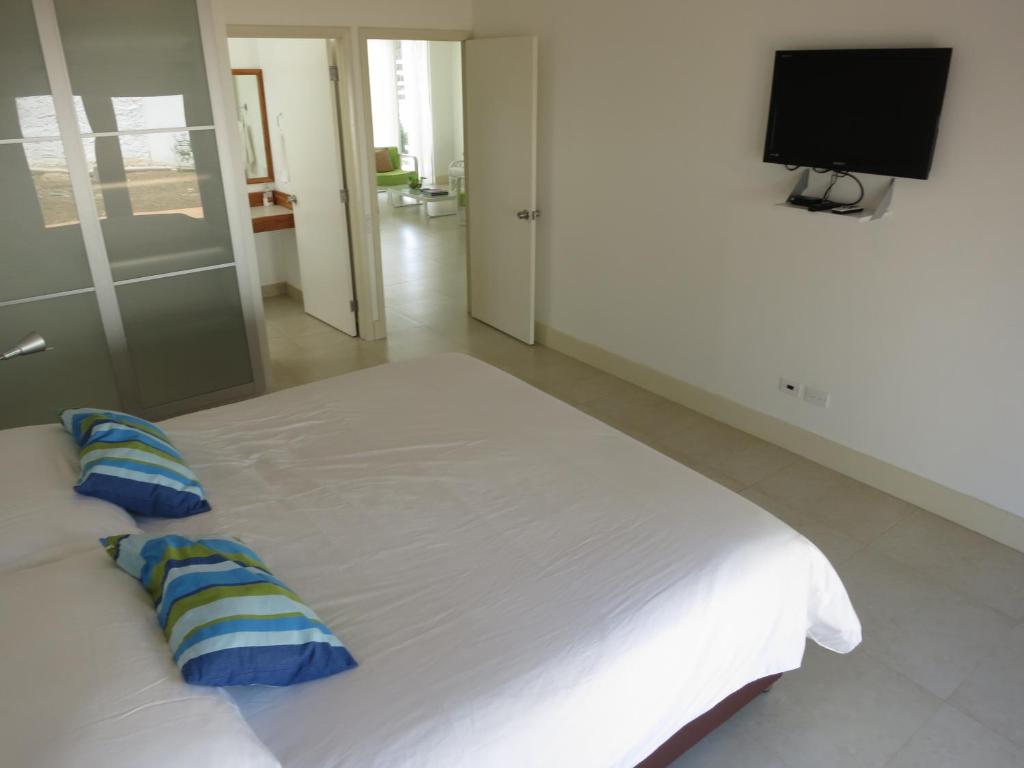 圣安德烈斯塔玛琳多公寓的卧室配有带蓝色枕头的大型白色床