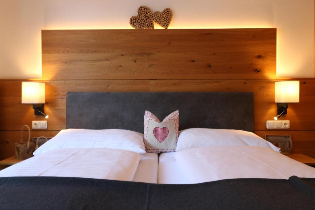 劳里斯布劳酒店的一张带白色枕头和木制床头板的床