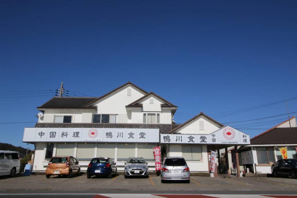 鸭川市Uhome Kamogawa Villa的前面有汽车停放的建筑