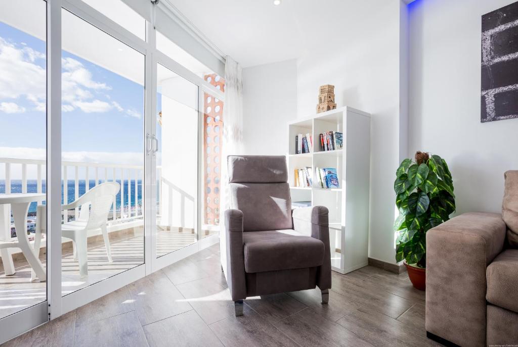 美洲海滩Apartment Torres Sunrises, Las Americas的一间带椅子的客厅和一个阳台