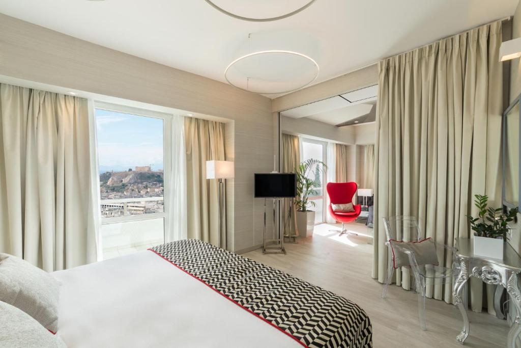 雅典St George Lycabettus Lifestyle Hotel的酒店客房设有一张床和一个大窗户