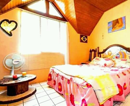 弗洛里亚诺波利斯Casa Hostel Mosaicos DyA的一间卧室配有一张床、一张桌子和一个窗户。