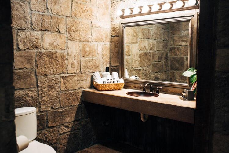 比尔顿The Inn at Zaca Creek的石质浴室设有水槽和镜子