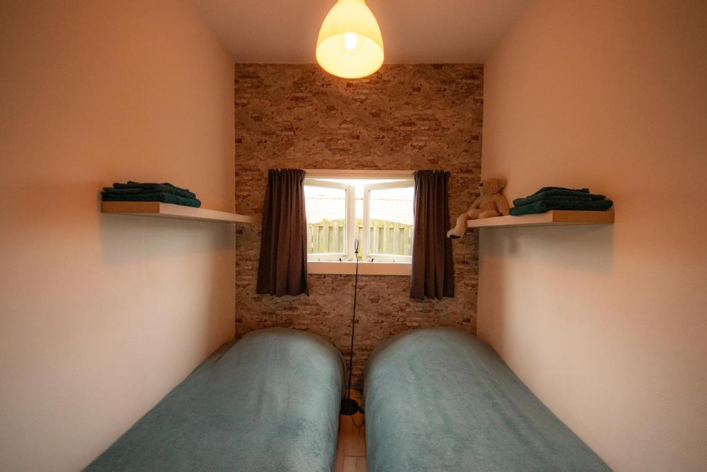 内斯De Cel的一间卧室设有两张床和窗户。