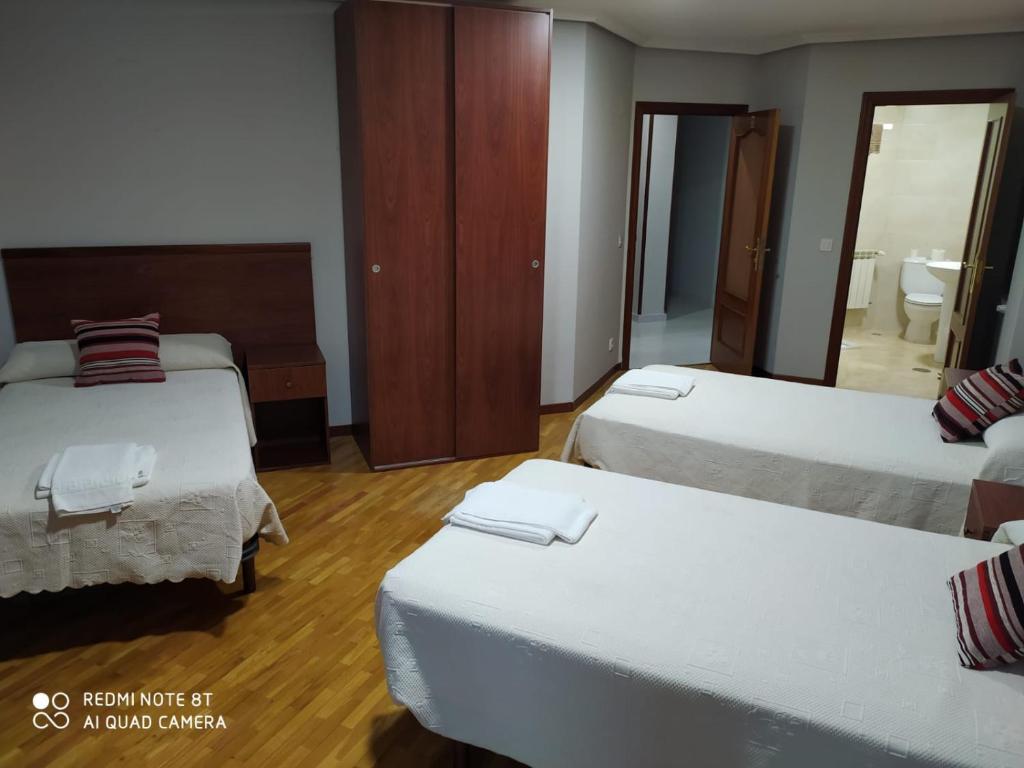 莱昂Hostal Cerecedo的酒店客房,设有三张床和镜子