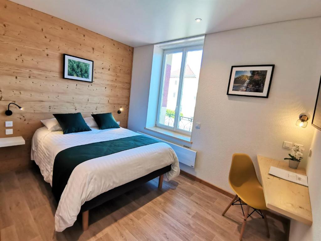 莫尔托Hotel Les Montagnards的一间卧室配有一张床、一张书桌和一个窗户。