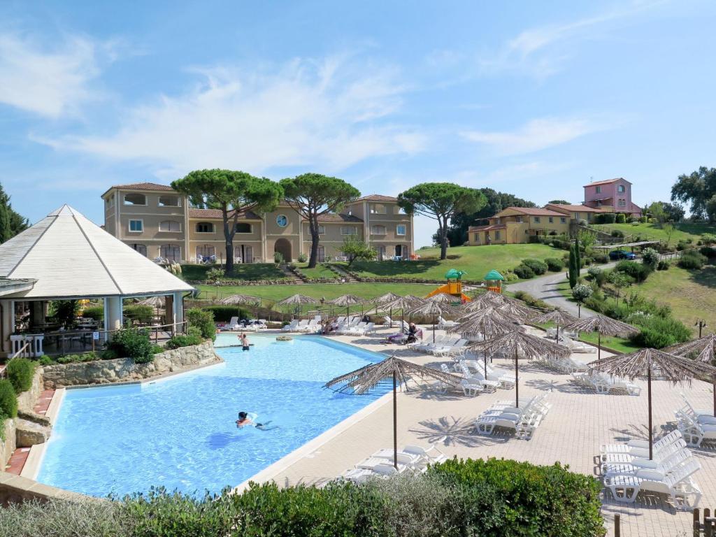 里帕尔贝拉Apartment Il Felciaione-5 by Interhome的度假村内带遮阳伞和人员的游泳池