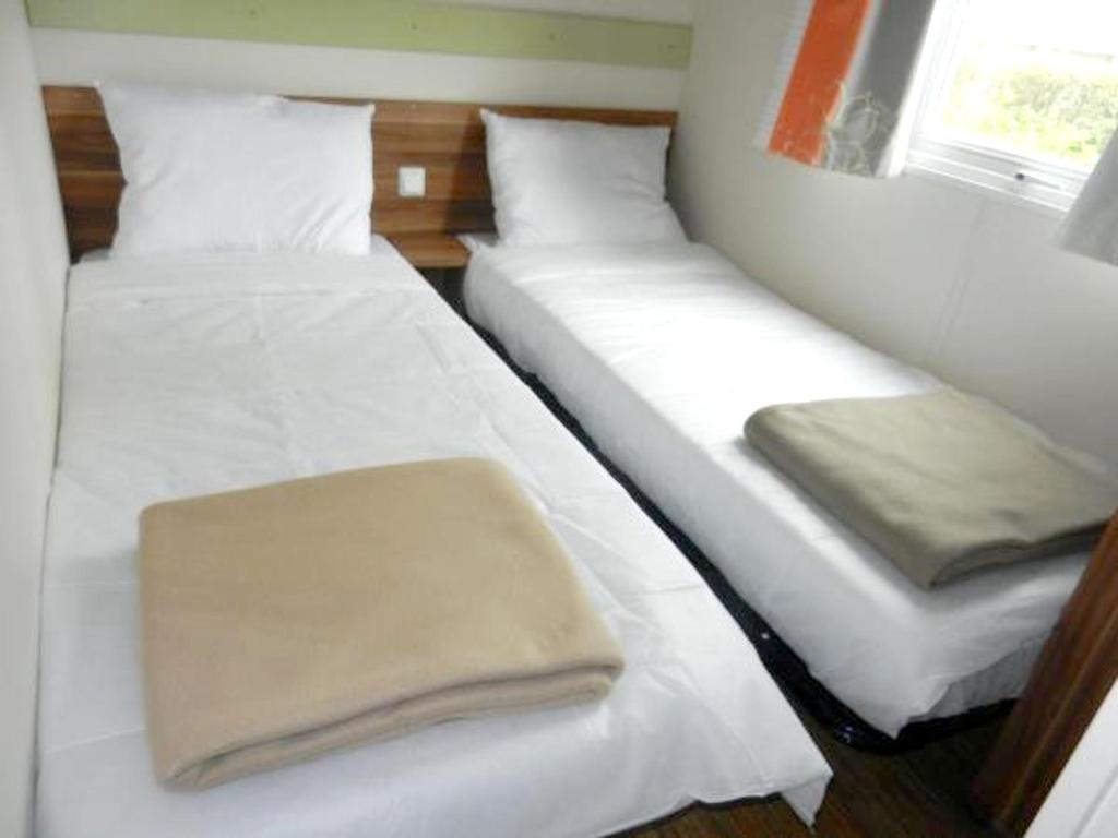 特罗格Bungalow de 3 chambres avec piscine partagee et terrasse amenagee a Trogues的配有白色床单的客房内的两张床