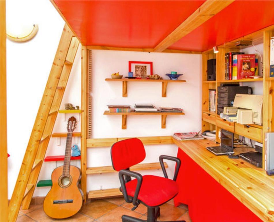 罗马Studio with enclosed garden and wifi at Roma的一间小房子,配有红色椅子和吉他
