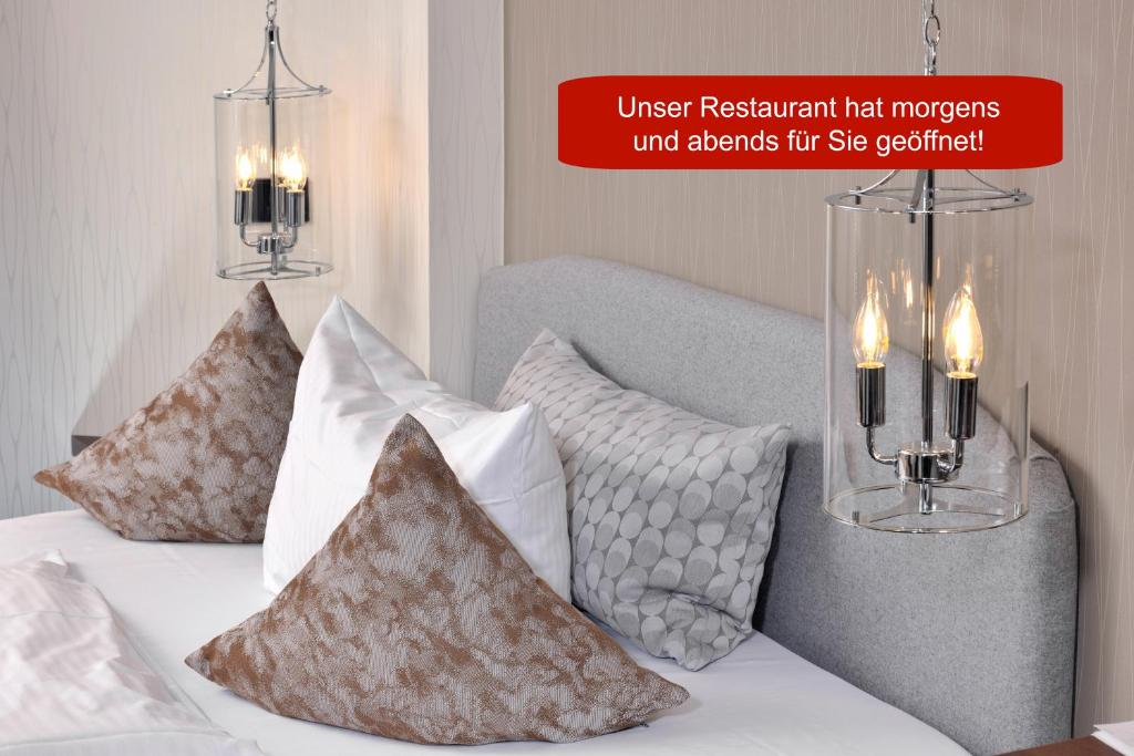 兰格瑙维斯瑟斯洛斯鲁宾格酒店的一间卧室配有带枕头的床铺和2个吊灯。