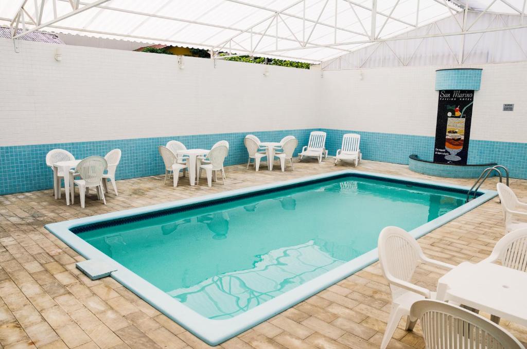 巴拉奈里奥-坎布里乌圣马力诺卡西诺酒店 的游泳池配有桌椅和桌椅