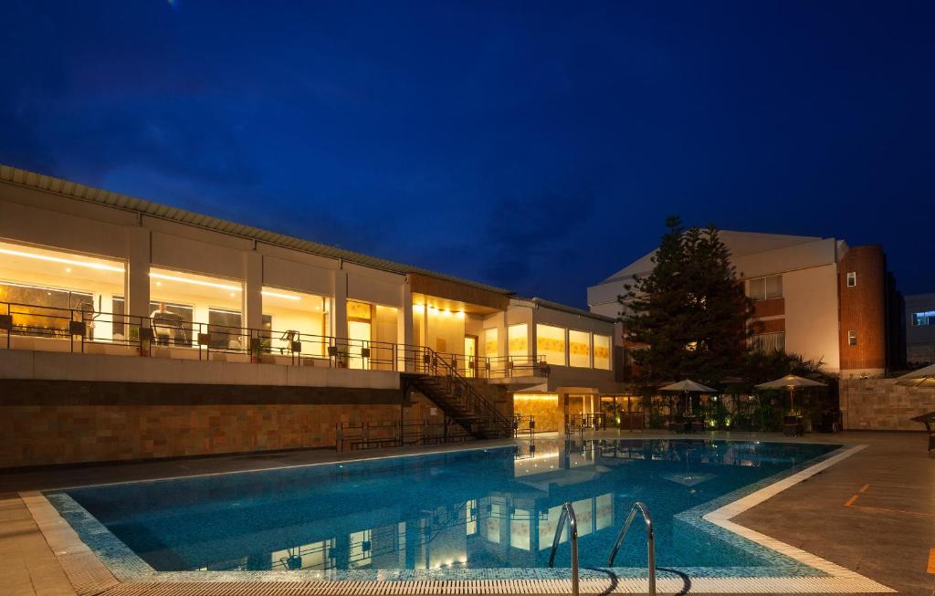 西里古里西里古里辛克莱酒店的一座游泳池,在晚上在建筑物前