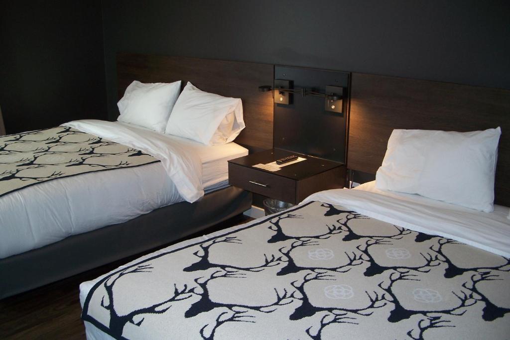 西黄石Terra Nova Cabins的酒店客房设有两张床和床头柜。
