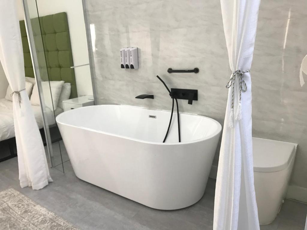 MinworthApartment style Space的带白色浴缸的浴室和卫生间