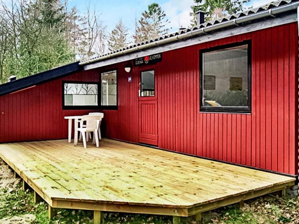 瑞伊5 person holiday home in Ry的红色的小房子,设有木甲板
