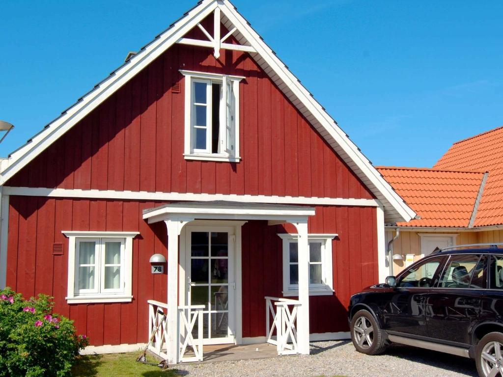 布拉万德6 person holiday home in Bl vand的前面有一辆汽车停放的红色房子