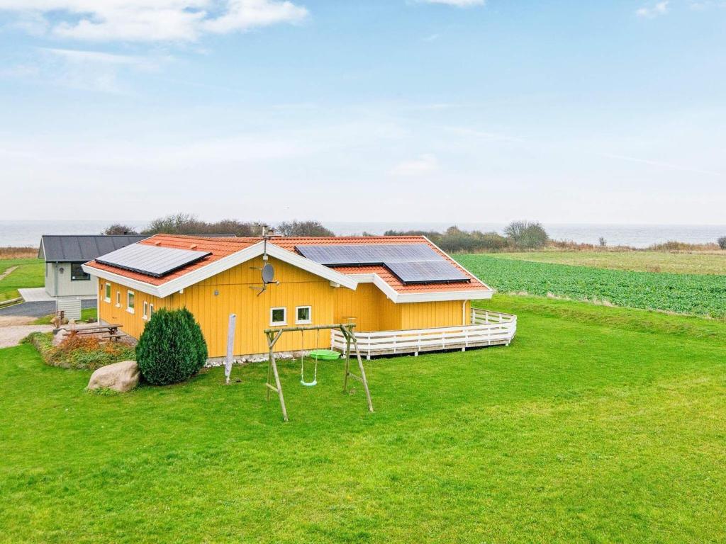 诺德堡8 person holiday home in Nordborg的绿色田野顶部的太阳能电池板房子