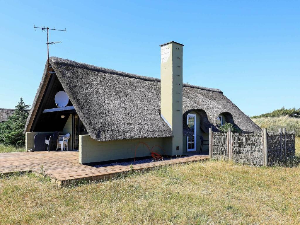 克莱戈德Holiday Home Kræ的茅草屋顶和木甲板的房子