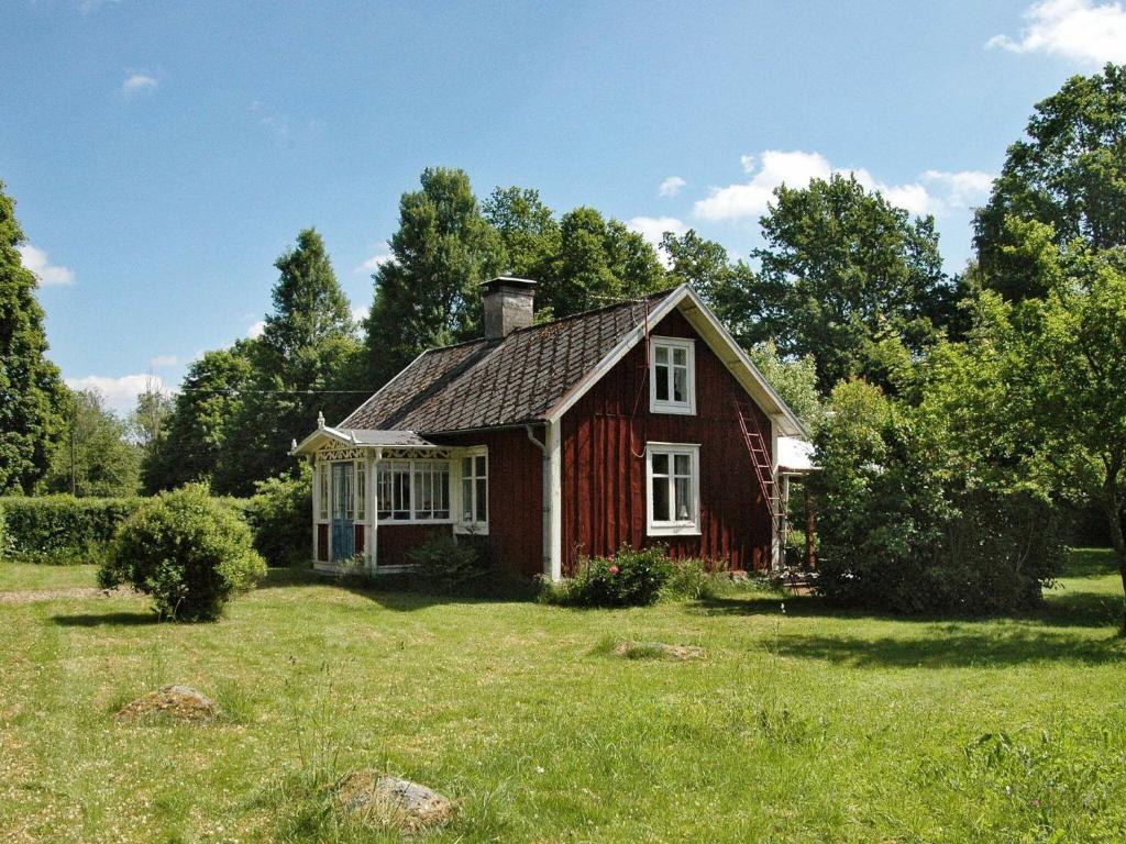 Kalvsvik5 person holiday home in KALVSVIK的草场上的一座红色小房子