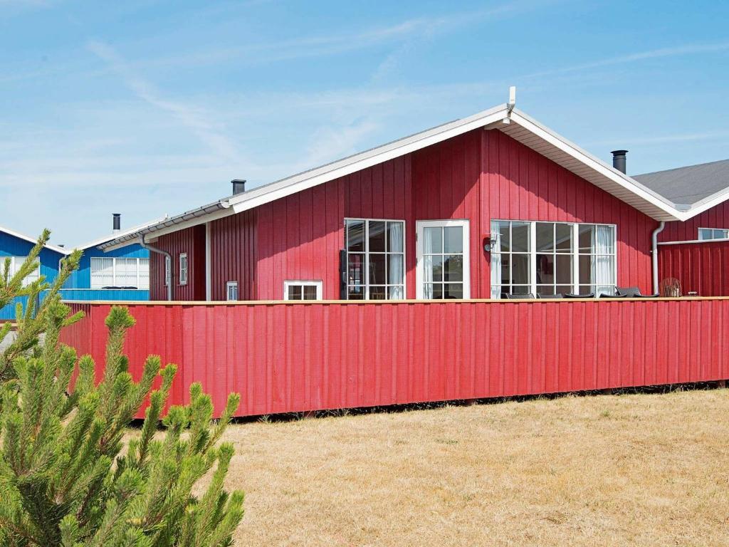 维泽桑讷6 person holiday home in Hvide Sande的红色的房子,有红色的栅栏