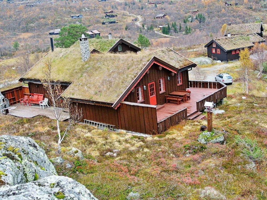 Vågsli11 person holiday home in Edland的山坡上带草屋顶的小木屋