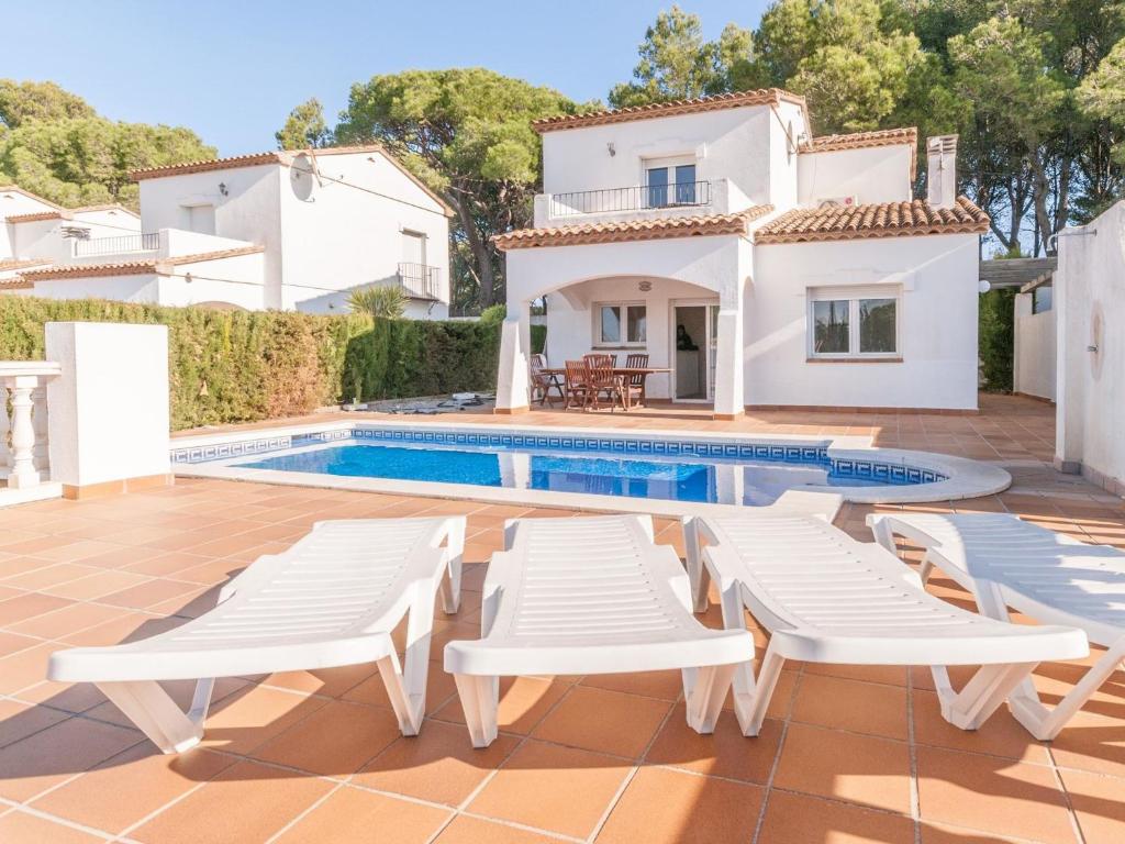 莱斯卡拉Pretty Holiday Home in L Escala with Swimming Pool的一座带游泳池和房子的别墅