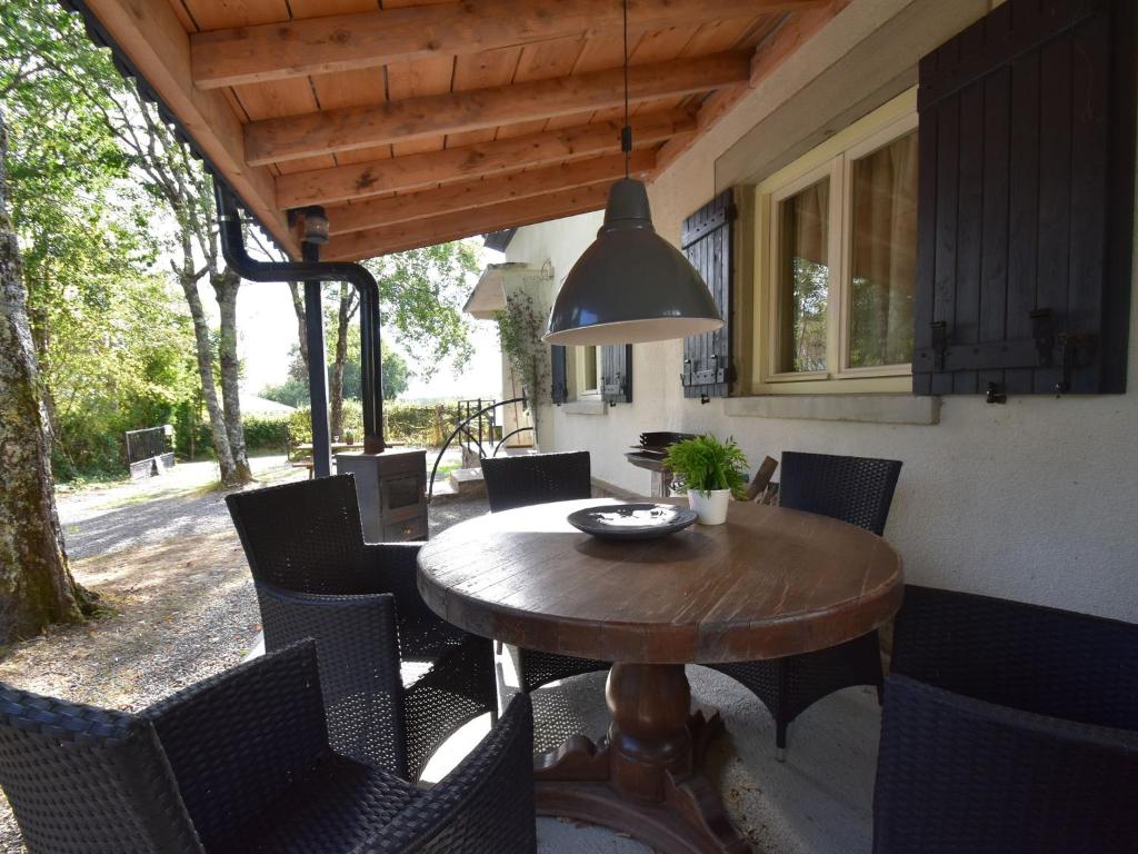 Saint-Honoré-les-BainsModern holiday home with lovely garden的天井上的木桌和椅子