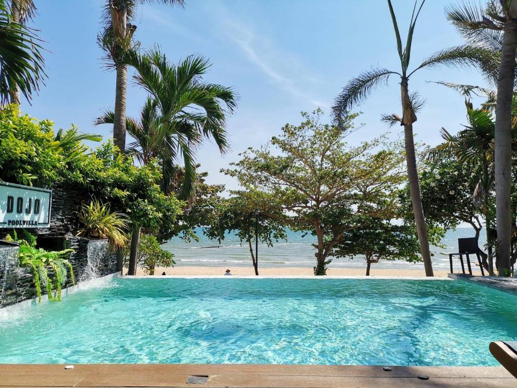 乔木提恩海滩Dojo pool villa的棕榈树海滩旁的大型游泳池