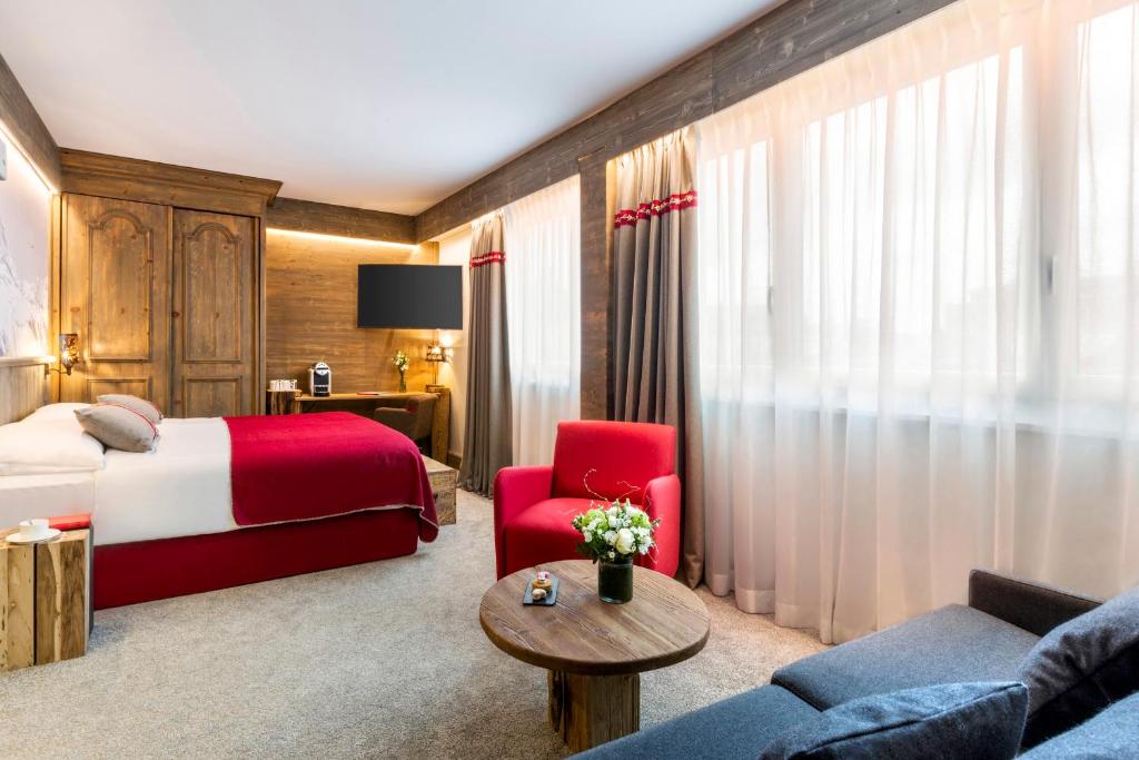 日内瓦雪绒花玛诺特酒店的酒店客房,配有一张床和一张红色椅子