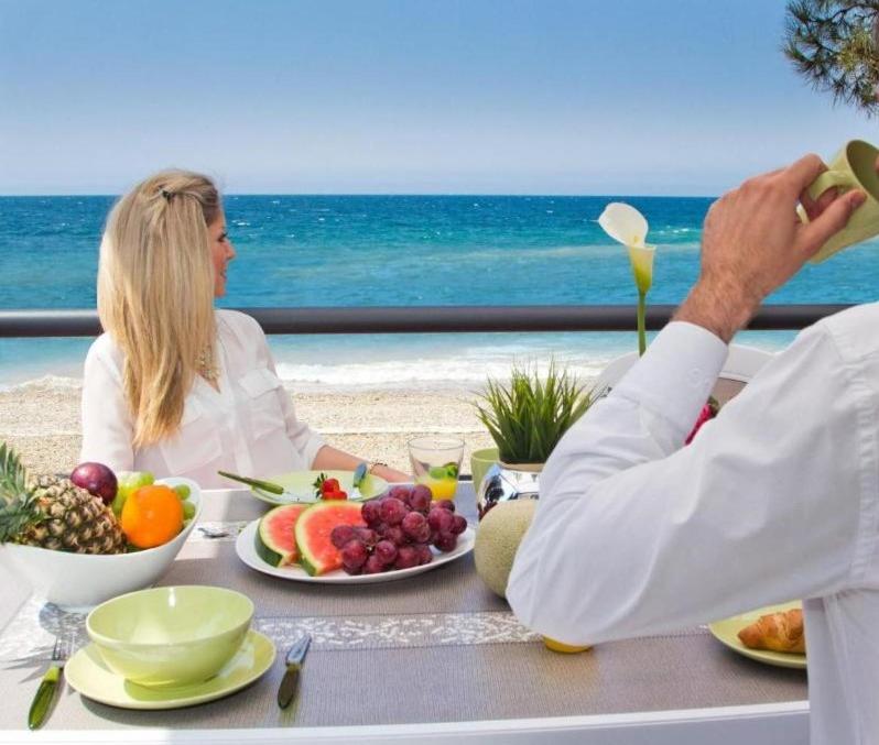 波雷奇Boutique Camping Materada Beach的坐在桌子上,有水果的男人和女人