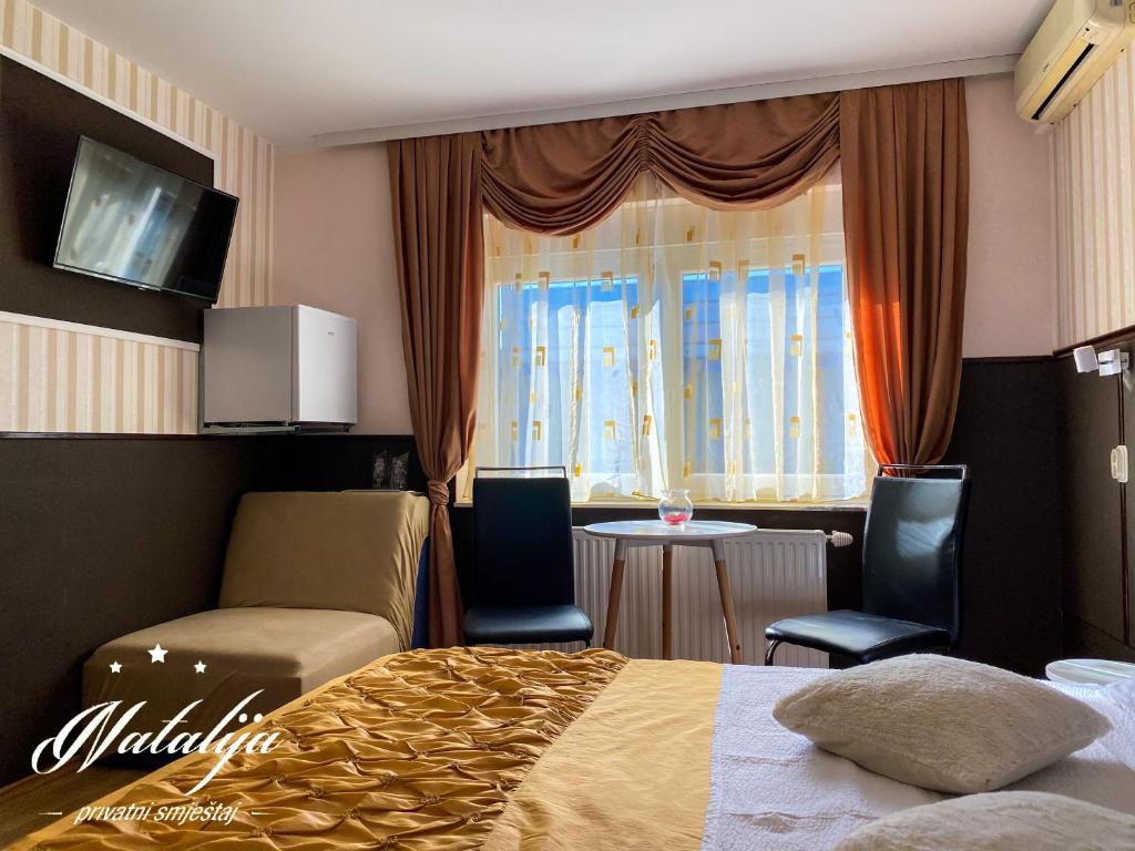 奥西耶克Smještaj Natalija的酒店客房带一张床、一张桌子和椅子
