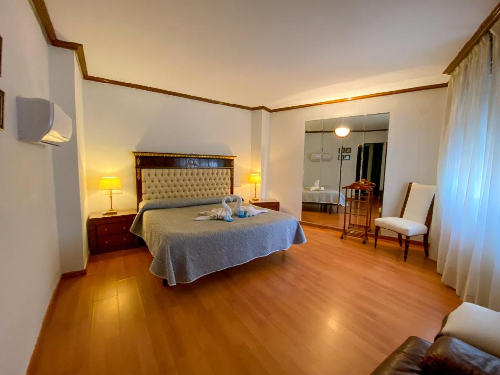 阿尔巴塞特卡迪纳尔酒店的一间卧室配有一张床和一把椅子