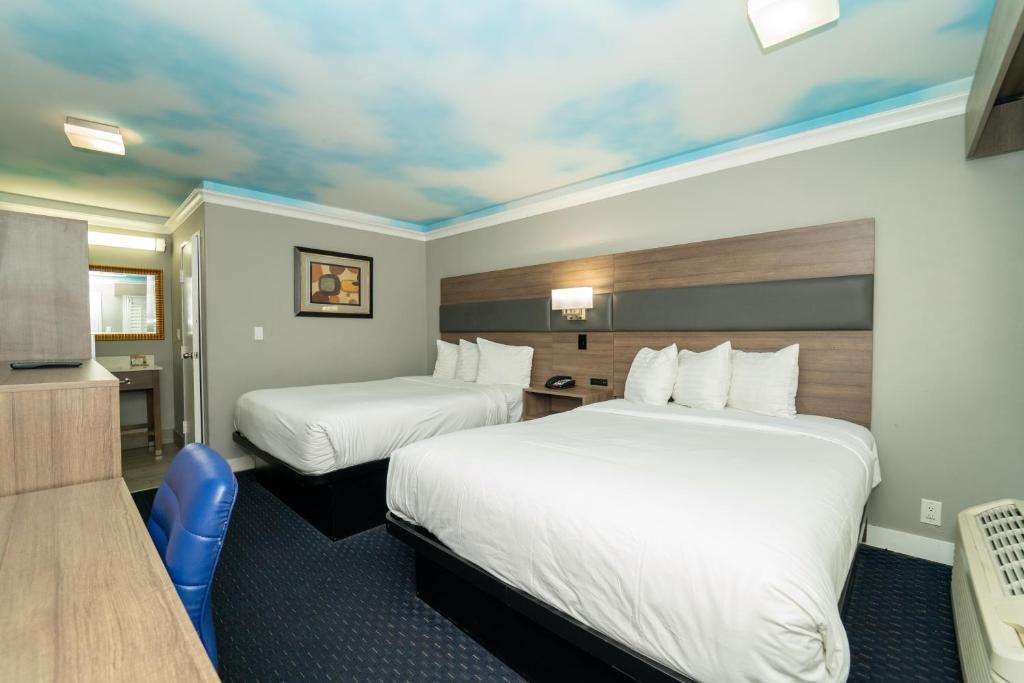 洛杉矶好莱坞棕榈旅馆&套房酒店的酒店客房设有两张床和电视。