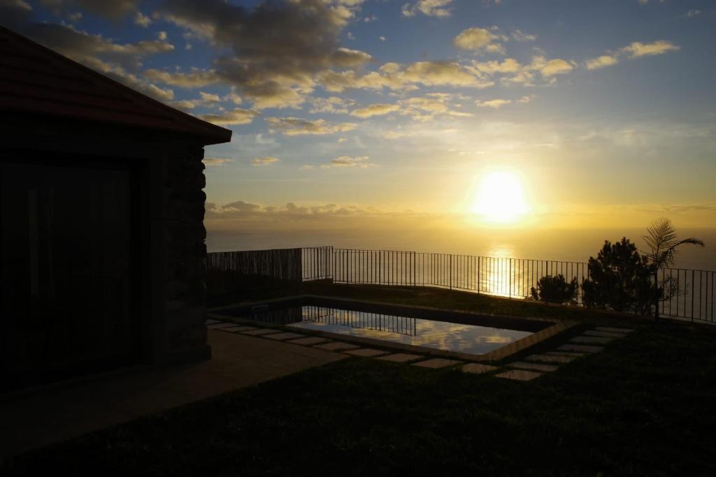 蓬塔杜帕戈north&south views calheta的从房子后院可欣赏到日落美景