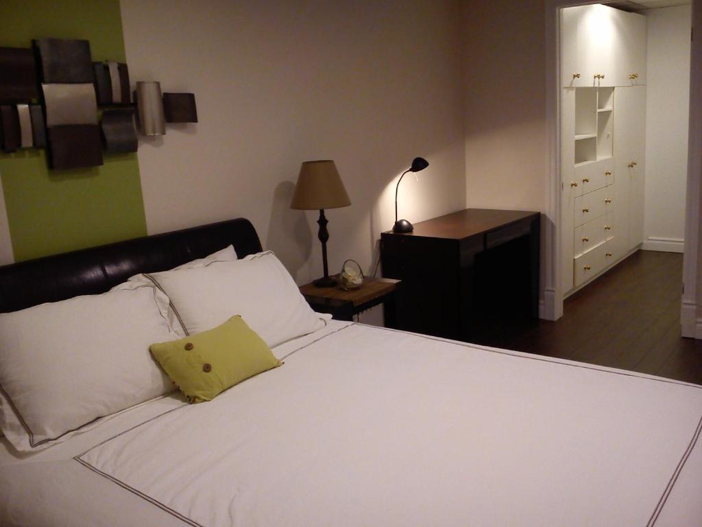 圣费利西安贝尔维尤公寓的卧室配有白色的床和黄色枕头