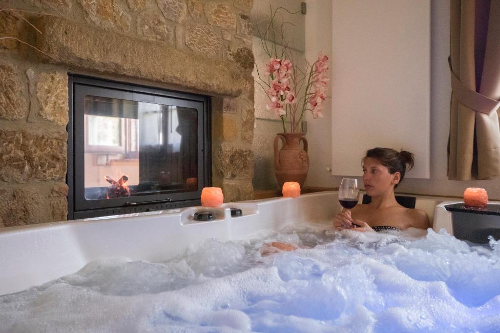 皮恩扎博内罗农庄旅馆的坐在浴缸里的女人,喝一杯葡萄酒
