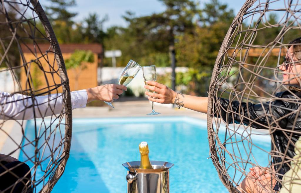科里米诺VSG Resort的两人在泳池旁拿着酒杯