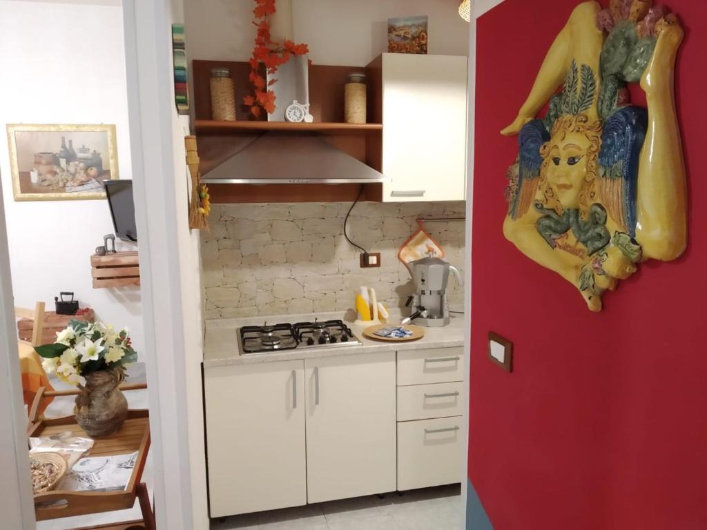 莫迪卡La Casa di Pina的厨房配有白色橱柜和红色墙壁