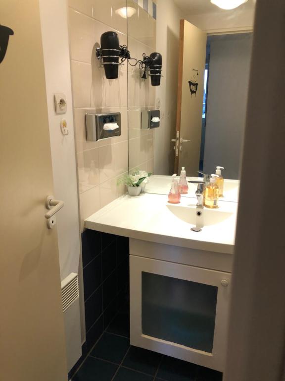 库尔布瓦Ryan Homes - in ApartHotel - La Défense的浴室设有白色水槽和镜子