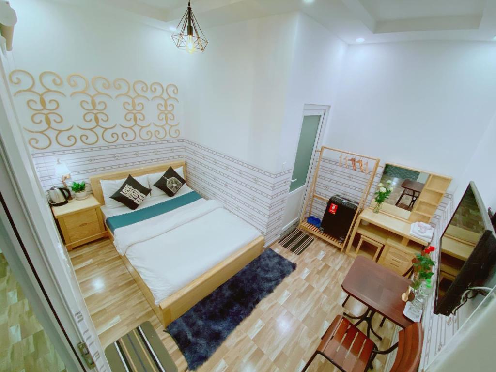大叻Dalat Hills Hotel的小房间设有一张床和一张书桌