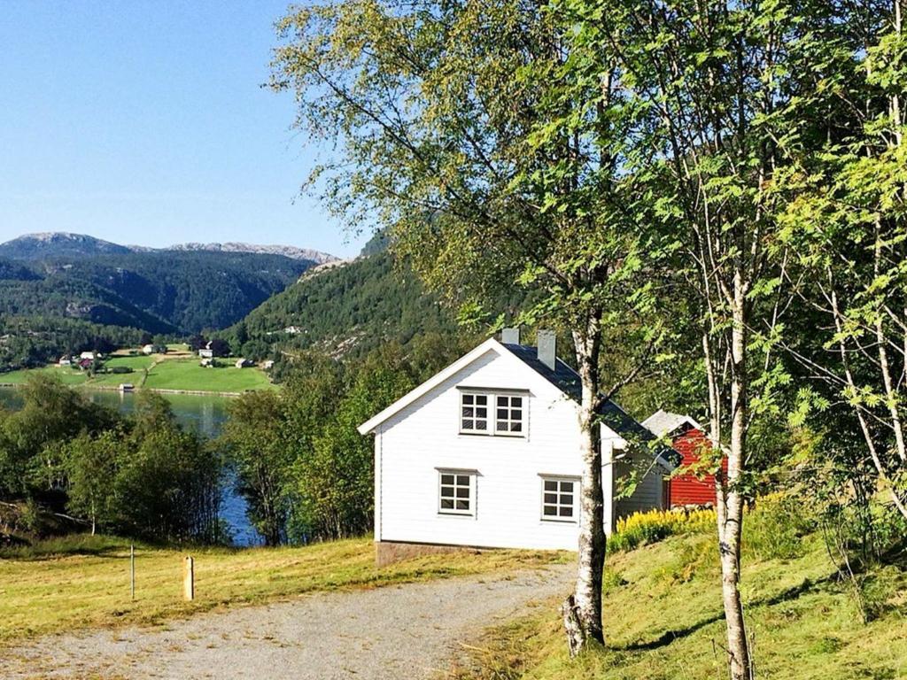 MasfjordenHoliday home Masfjordnes的湖畔小山上的白色房子