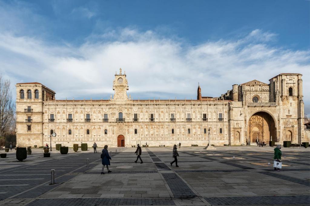 莱昂Parador de Turismo de León的一座大型建筑,前面的人在步行