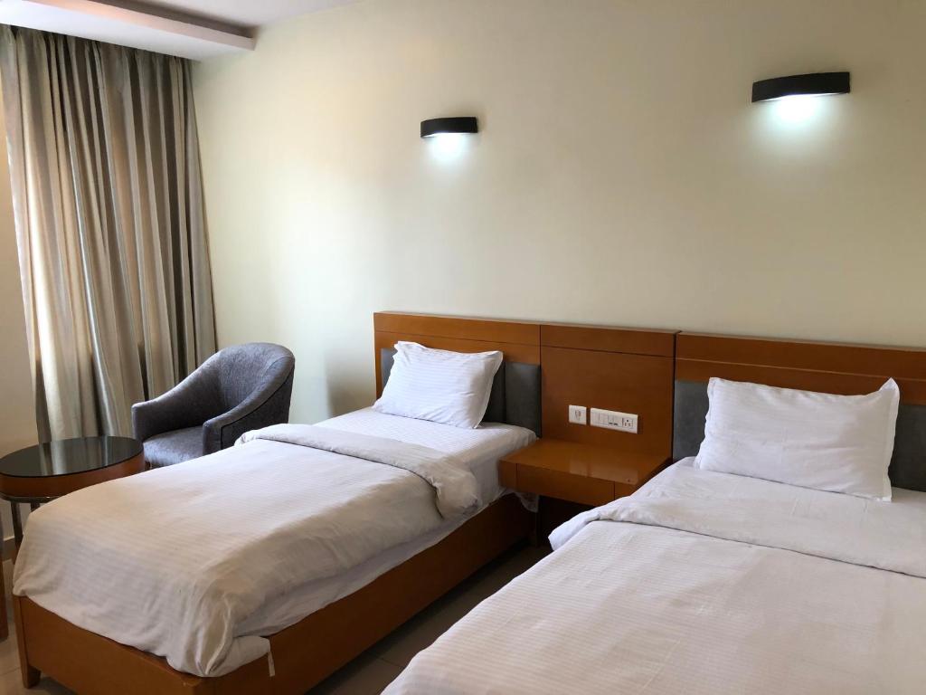 拉加蒙德里Leela pavilion的酒店客房,配有两张床和椅子